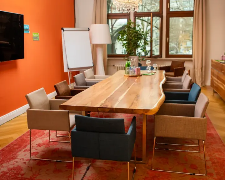Seminarraum mit langem Holztisch und Flipchart